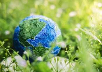 TIerra. Foto World Earth Day Concept. Green Energy, ESG, Renewable and Sustainable Resources. Environmental Care. Globe Lay on Green Grass