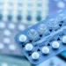 Oral contraceptive pill on pharmacy counter with colorful pills strips background.
