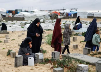 Palestinian women visit graves of people who were killed in the ongoing conflict between Israel and Palestinian Islamist group Hamas, on the day of Eid al-Fitr, in Rafah, in the southern Gaza Strip April 10, 2024. REUTERS/Mohammed Salem     TPX IMAGES OF THE DAY