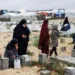 Palestinian women visit graves of people who were killed in the ongoing conflict between Israel and Palestinian Islamist group Hamas, on the day of Eid al-Fitr, in Rafah, in the southern Gaza Strip April 10, 2024. REUTERS/Mohammed Salem TPX IMAGES OF THE DAY