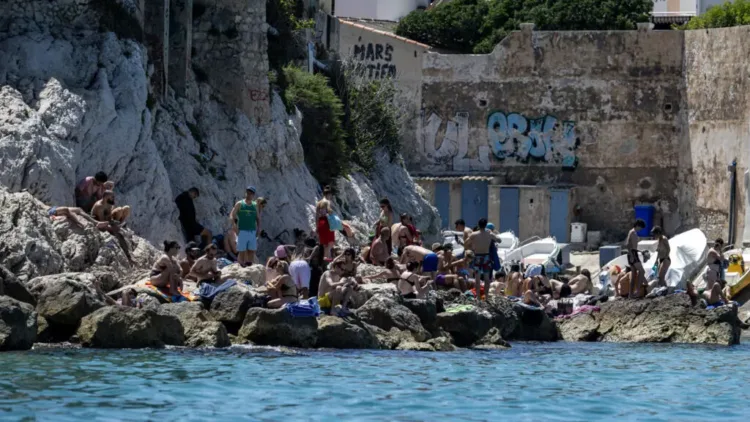 Decenas de personas combaten la ola de calor en una playa de Marsella, en el sur de Francia, este fin de semana de junio de 2026.