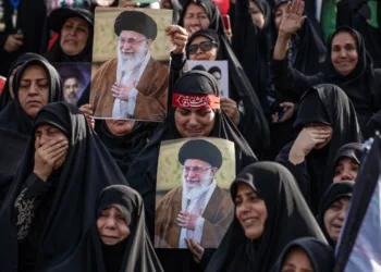 Un grupo de personas sostiene retratos del fallecido líder supremo de Irán, el ayatolá Alí Jamenei, al comienzo de las ceremonias fúnebres.