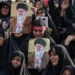 Un grupo de personas sostiene retratos del fallecido líder supremo de Irán, el ayatolá Alí Jamenei, al comienzo de las ceremonias fúnebres.